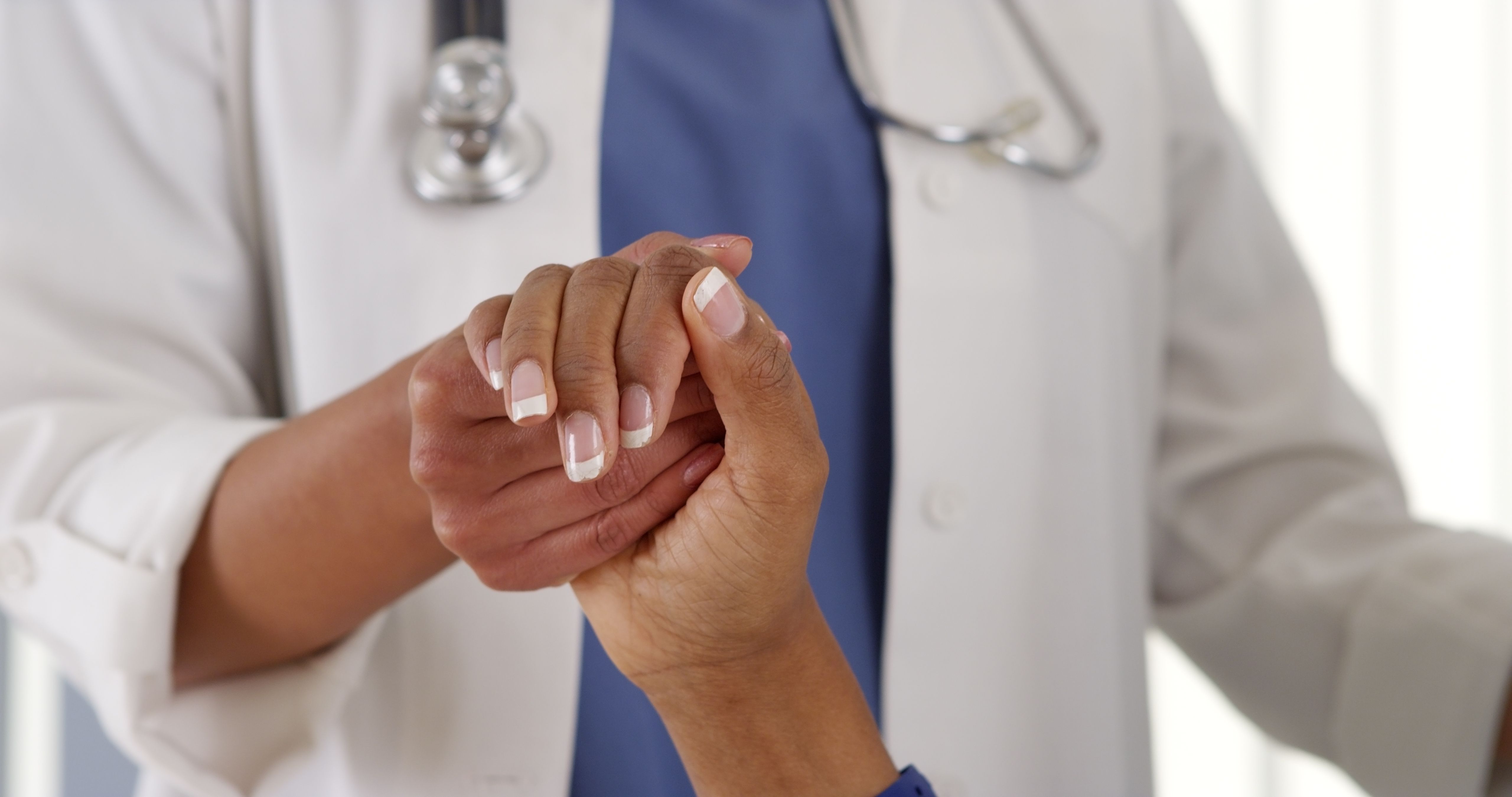 Patient holding hand of physician.
