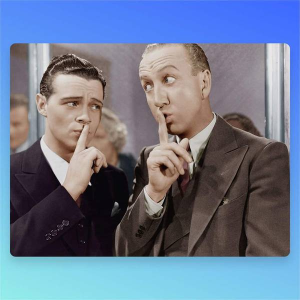 Two men in suits signaling for silence with fingers over their lips in vintage photo.