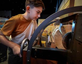 A child is playing with a model mutoscope