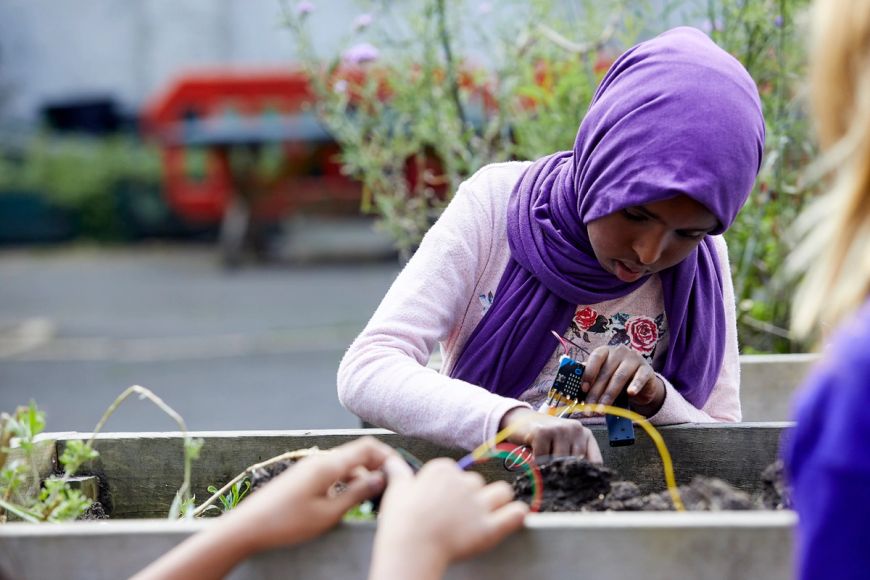 Child using the micro:bit to check soil temperature