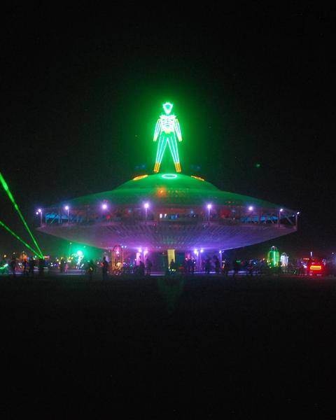 Neon man on top of spaceship structure at Burning Man